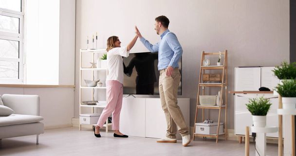 Smiling Young Couple Carrying New Television At Home - Photo, Image