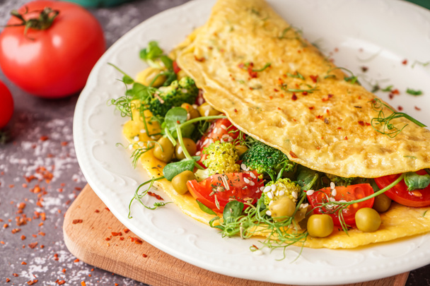 Lekkere omelet met groenten op grijze grunge achtergrond - Foto, afbeelding