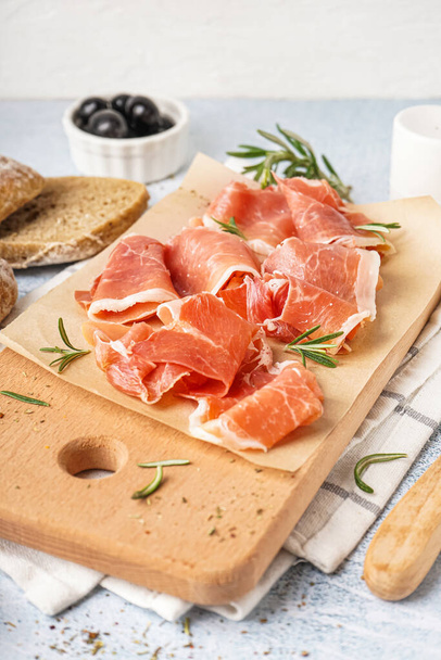 Wooden board with slices of tasty jamon on light background - Photo, Image