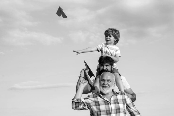 Happy man family have fun together. Kid pilot with toy jetpack against sky background. Family holiday and togetherness. Dad and son. Excited teach - Фото, зображення