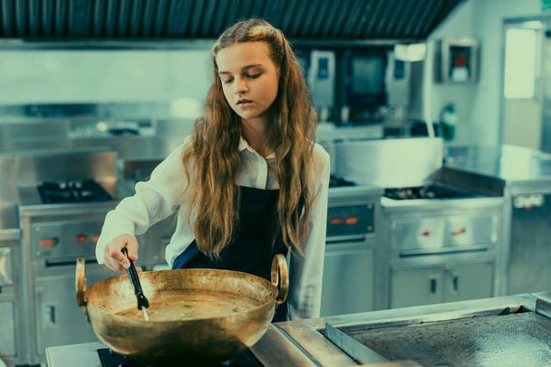 In culinary school, teenager learn from real chefs how to make sorts of tasteful food. Cooking spaghetti is a hands-on practice that engages students' sense of taste and smell as they follow recipes - Foto, immagini