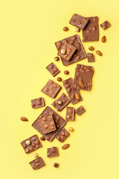 Sweet tasty chocolate with nuts on  yellow background - Foto, Imagem