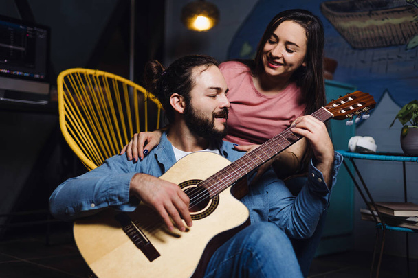 young latin couple playing guitar in a romantic date, Girlfriend and boyfriend having fun at home at night in Mexico Latin America, hispanic people - Fotografie, Obrázek