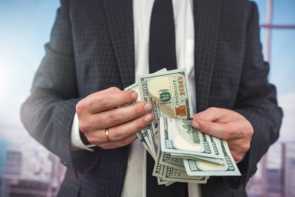 mani maschili che contano banconote in dollari in ufficio. concetto ricco - Foto, immagini