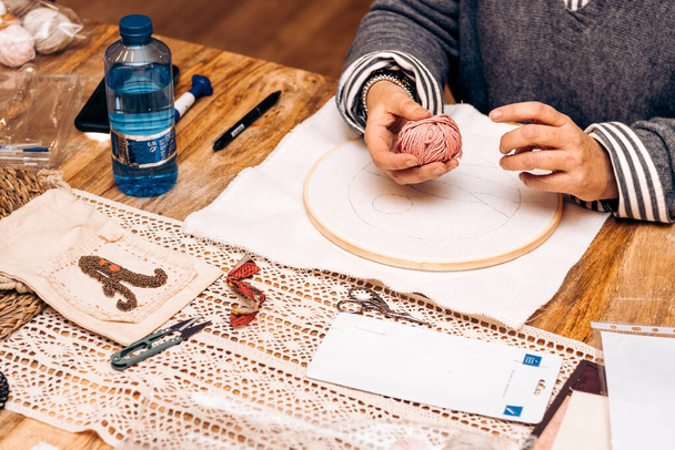 Punch Needle Workshop. Frau mittleren Alters mit einem Knäuel Strickwolle in der Hand. - Foto, Bild