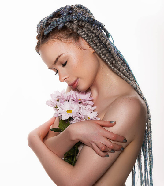 Retrato de belleza de una mujer joven con la piel sana y flores rosadas cerca de la cara - aislado en blanco. Linda cara para productos de salud o belleza - Foto, imagen