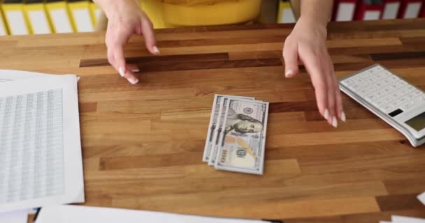 Nainen asettaa dollareita pöydälle virassa. Taloudelliset investoinnit ja käteisvoitto - Materiaali, video