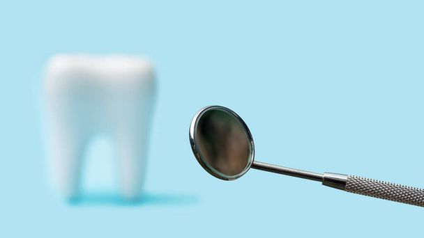 Falsche Zähne und normaler Mundspiegel auf blauem Hintergrund. - Foto, Bild