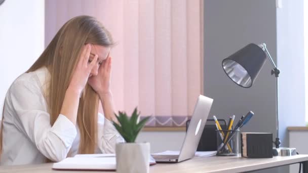 Müde Geschäftsfrau sitzt an ihrem Schreibtisch vor dem Computer. Kopfschmerzen bei der Büroarbeit. 4k-Video - Filmmaterial, Video