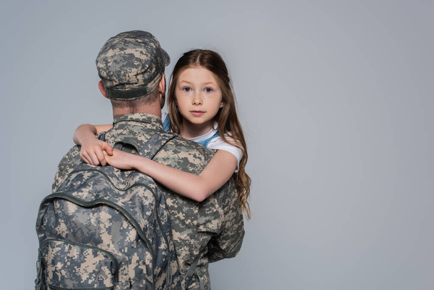 daughter hugging father in military uniform during homecoming isolated on grey  - Φωτογραφία, εικόνα