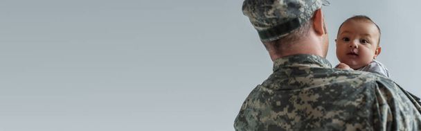 niño recién nacido en armas de soldado en uniforme militar aislado en gris, bandera  - Foto, Imagen