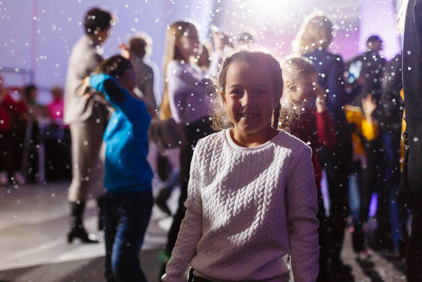 маленька дівчинка і штучний сніг на вечірці
. - Фото, зображення