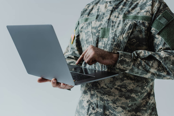 cropped view of soldier in army uniform using laptop isolated on grey  - Foto, immagini