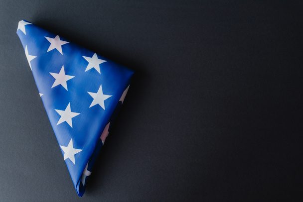vista superior de la bandera plegada de Estados Unidos en forma de triángulo aislado en negro  - Foto, Imagen