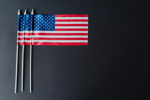 Flache amerikanische Flaggen mit Sternen und Streifen für den Gedenktag isoliert auf schwarz  - Foto, Bild