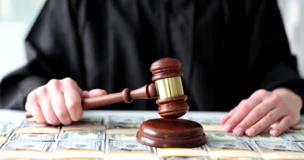 Судья стучит деревянным молотком по долларовым купюрам крупным планом. Финансовое мошенничество и судебные процессы - Кадры, видео