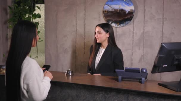 Vrouw die creditcard aanraakt aan kaartlezer terminal om te betalen voor hoteldiensten - Video