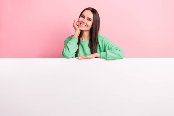 Photo of adorable gorgeous woman with straight hairdo dressed green sweatshirt hold hand under chin isolated on pink color background. - Foto, immagini