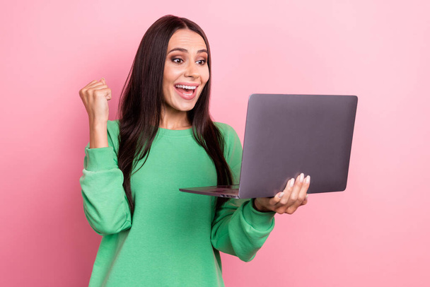 Photo of optimistic impressed woman straight hair dressed green sweatshirt win lottery yell hold laptop isolated on pink color background. - Foto, Imagen