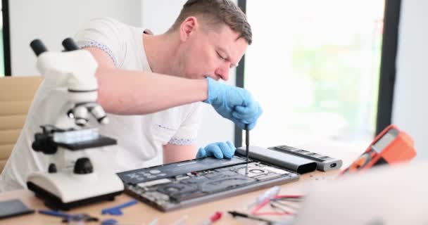 Engenheiro mestre desaperta detalhes de laptop quebrado na mesa em close-up oficina. Serviços de reparação electrónica de dispositivos - Filmagem, Vídeo
