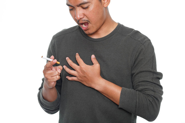 Homem fumando um cigarro e sentindo dor no peito. Doenças do coração ou do pulmão conceito - Foto, Imagem