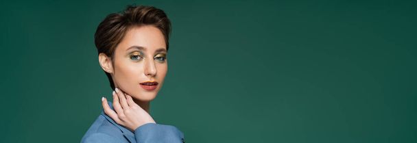 pretty young woman with short hair posing in blue blazer on turquoise green background, banner  - Photo, Image