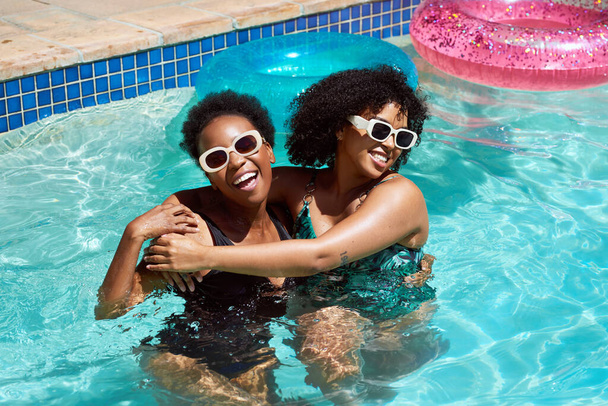 Due amici si rinfrescano in piscina, abbracciandosi ridendo divertendosi. Foto di alta qualità - Foto, immagini