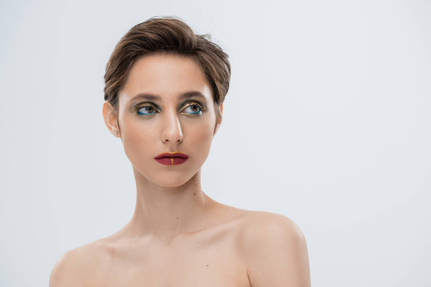 portrait of young woman with shiny makeup and short hair isolated on grey  - Foto, Imagem
