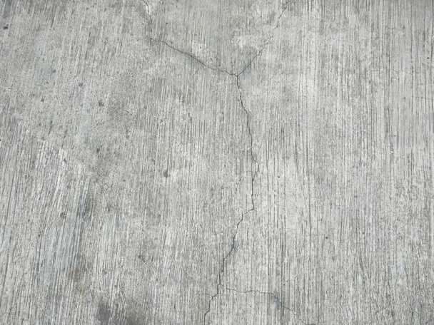podlaha domu z hrubého cementu se vzorkem rovných čar. Některé části podlahy začaly praskat kvůli vystavení dešti nebo horkému počasí - Fotografie, Obrázek