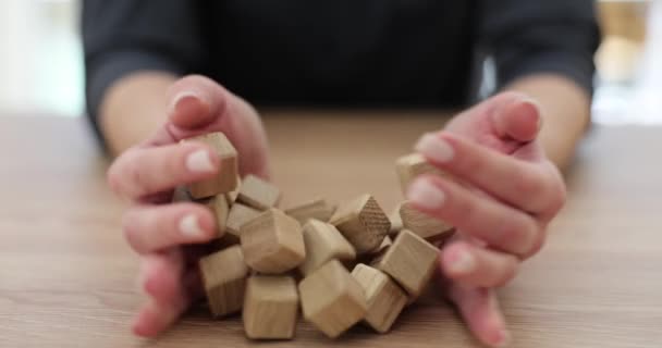 Le mani di donna versano cubi di legno su tavolo. Trovare soluzioni creative obiettivo e concetto di motivazione - Filmati, video