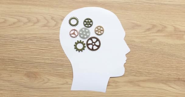 Menselijke hersenen met metalen tandwielen op papieren beeldje. Vorming van denkprocessen van kinderen en volwassenen - Video