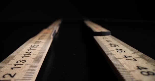 Closeup of two wooden rulers on black background. Construction line - Footage, Video