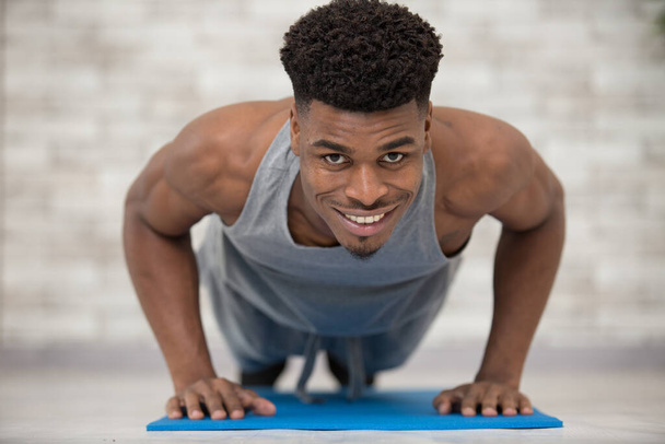 young black african man portrait doing push up exercise - Valokuva, kuva