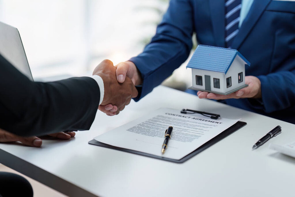 Realitní agent a klient potřesení rukou po podpisu smlouvy a o pojištění domu a investiční úvěr. - Fotografie, Obrázek