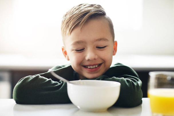 He loves breakfast. an adorable little boy having breakfast while sitting in the kitchen - Photo, Image