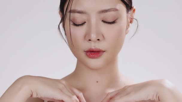 Close up retrato de beleza jovem asiático rosto feminino com pele saudável compõem no fundo branco. - Filmagem, Vídeo