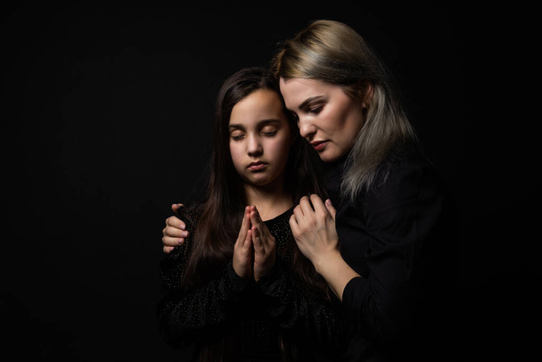 Religious Christian girl and her mother praying. - Photo, Image