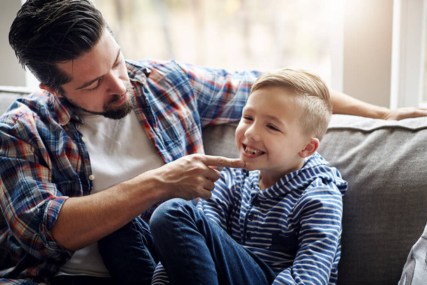 Lets see that cute little smile. a father and his little son bonding together at home - Фото, изображение