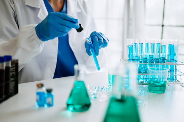 Biotechnolog męski badający nowe substancje chemiczne w laboratorium. - Zdjęcie, obraz