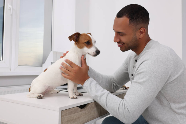 Young man with Jack Russell Terrier at desk in home office - Фото, зображення