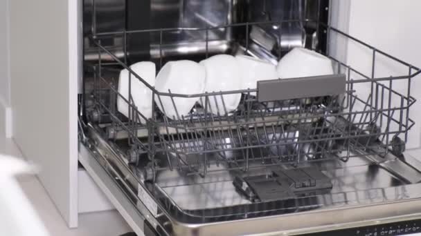 Mosogatás a mosogatógépből. Jól mosott, fényes edények automata mosogatógépben - Felvétel, videó