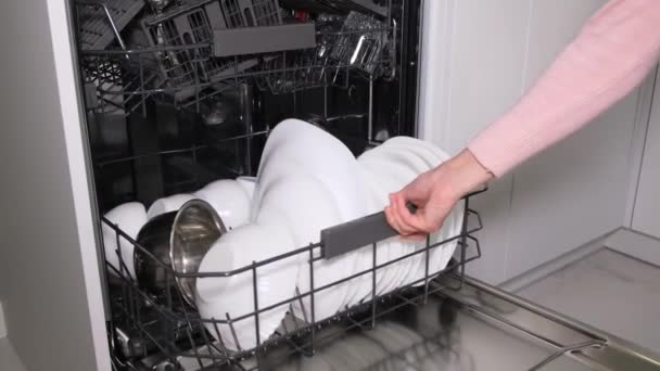 Descarregar pratos da máquina de lavar louça. Uma dona de casa tira pratos limpos de uma máquina de lavar louça automática - Filmagem, Vídeo
