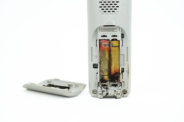 Batterie danneggiate e corrose in dispositivi elettronici isolati su sfondo bianco. - Foto, immagini