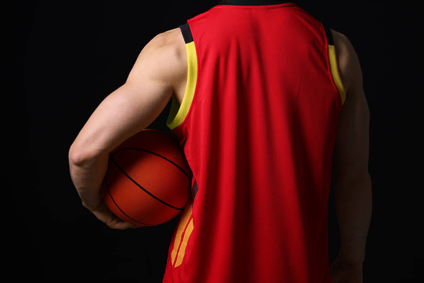 Athletic man with basketball ball on black background, closeup - Fotoğraf, Görsel