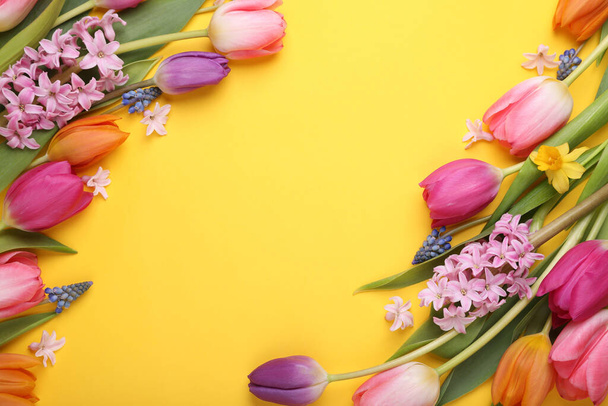 Beautiful different flowers on yellow background, flat lay. Space for text - Zdjęcie, obraz