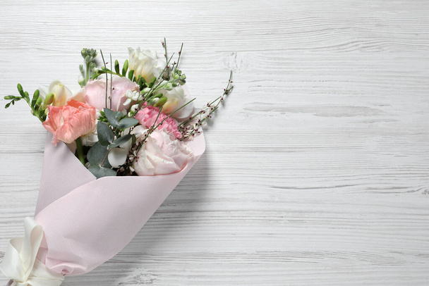 Bouquet of beautiful flowers on white wooden table, top view. Space for text - Fotoğraf, Görsel