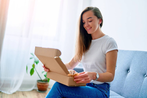 Happy joyful young satisfied shopaholic woman client sitting on couch at home and opening received carton parcel box, easy and fast service commerce delivery concept  - Foto, imagen