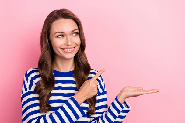 Photo of young optimistic girl wear shirt direct finger empty space hold hand cheap product shop prices isolated on pink color background. - 写真・画像