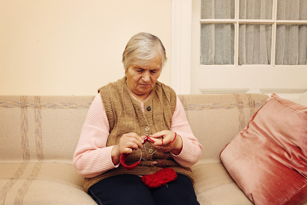 Femme âgée tricot avec laine rouge
 - Photo, image