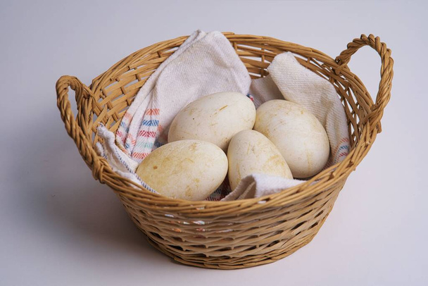 Huevos de oca en una cesta de mimbre - Foto, immagini